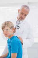 Doctor examining patient with magnifying glass