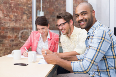 Smiling businessman looking at camera in meeting Smiling businessman looking at camera in meeting