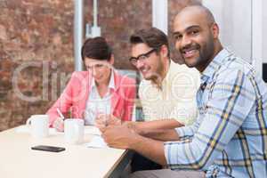 Smiling businessman looking at camera in meeting