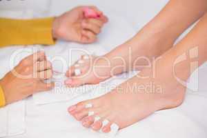 Womans toenails being painted by beautician