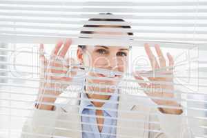 Woman glancing through some blinds