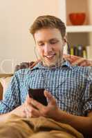 Young man listening to music on his couch