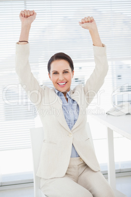 Smiling businesswoman celebrating at work