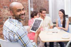 Businessman using her digital tablet smiling at camera