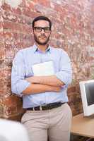 Serious businessman with arms crossed at office