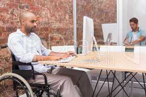 Focused businessman in wheelchair working at his desk