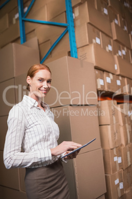 Female manager using digital tablet in warehouse