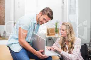 Business people smiling and working together with a laptop