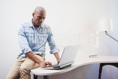 Casual businessman using his laptop at desk