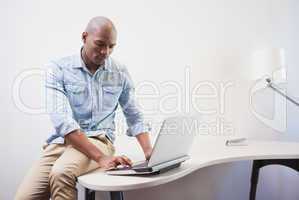 Casual businessman using his laptop at desk