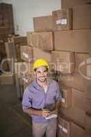 Worker with clipboard in warehouse