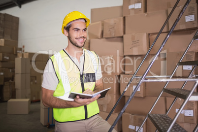 Worker with diary in warehouse