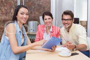 Smiling business people working on tablet pc