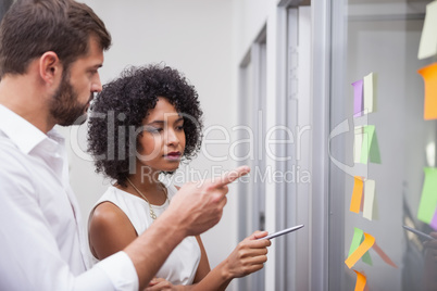 Casual business team looking at sticky notes