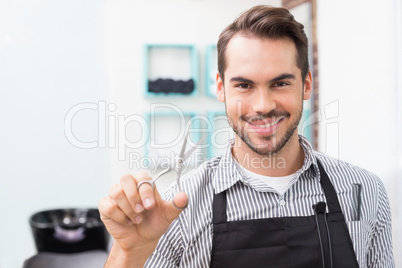 Handsome hair stylist holding scissors
