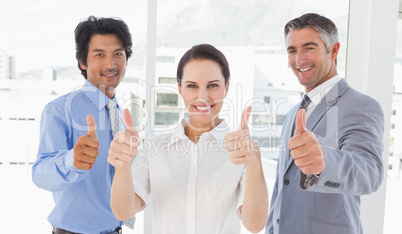 Happy work team giving thumbs up