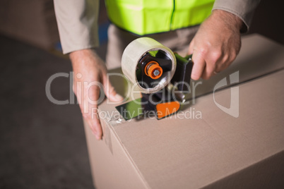 Mid section of worker preparing goods for dispatch