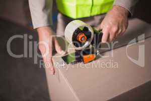 Mid section of worker preparing goods for dispatch