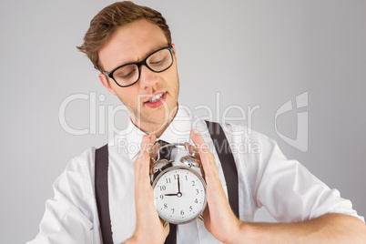 Geeky businessman holding alarm clock