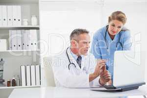 Doctor and nurse looking at laptop