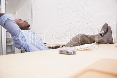 Businessman relaxing at desk and smiling