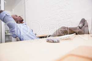 Businessman relaxing at desk and smiling