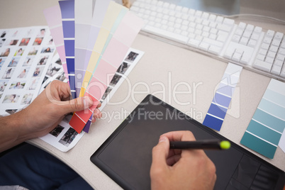 Designer using graphics tablet and colour charts