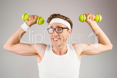 Geeky hipster posing in sportswear with dumbbells