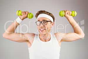 Geeky hipster posing in sportswear with dumbbells
