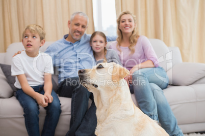 Parents and their children on sofa with puppy