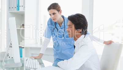 Doctor and surgeon looking at a computer