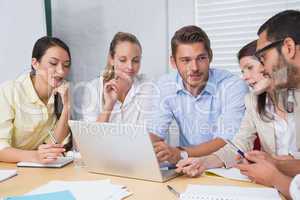 Casual business team having a meeting using laptop