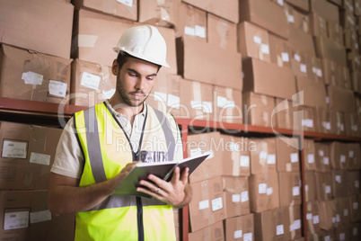 Worker with diary in warehouse