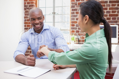 Casual business people shaking hands at desk