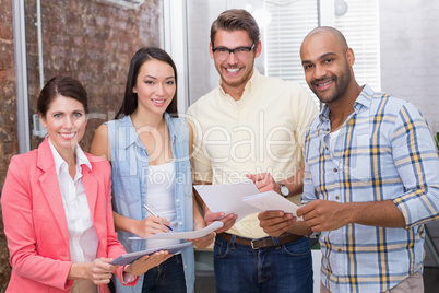 Business people looking at tablet pc and holding paperwork