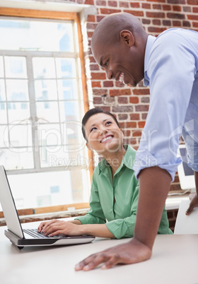 Casual business team working together with laptop