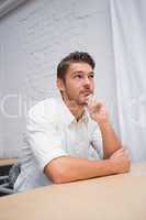 Thoughtful businessman looking away at office