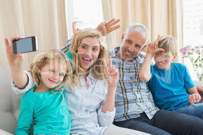 Happy family taking a selfie on couch