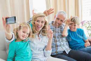 Happy family taking a selfie on couch