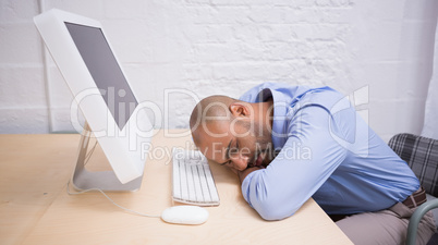 Businessman sleeping by computer at desk