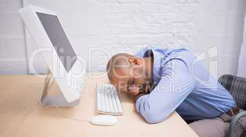 Businessman sleeping by computer at desk