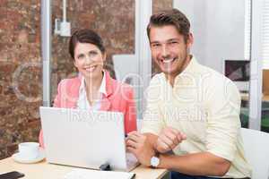 Business people working together on laptop and smiling