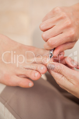 Pedicurist clipping customers toe nails
