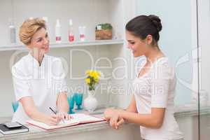 Pretty beautician talking with client