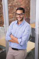 Smiling businessman with arms crossed at office