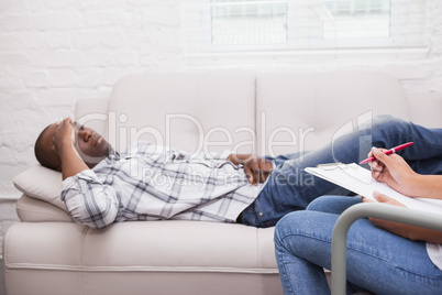 Man lying on sofa talking to his therapist