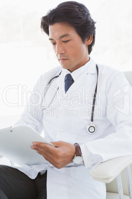 Focused doctor reading over notes