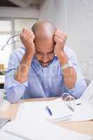 Tired businessman with paperwork at desk