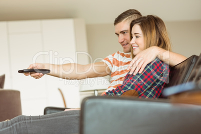Cute couple relaxing on couch watching tv