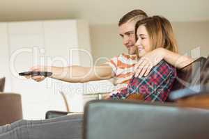 Cute couple relaxing on couch watching tv